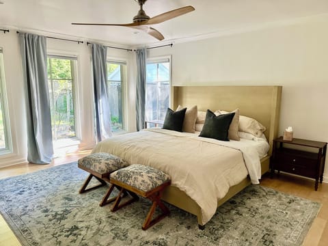 Bright king bedroom with garden views, large windows, and elegant seating