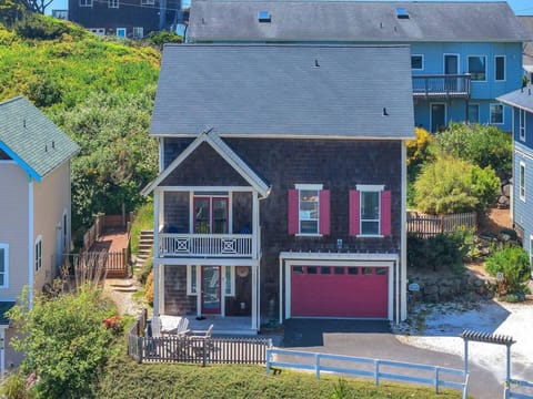 Charming coastal cottage nestled among lush greenery in a quiet residential neighborhood, with easy parking and welcoming architecture setting the stage for your seaside getaway.