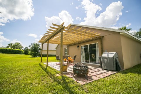 Outdoor seating with grill and covered pergula.