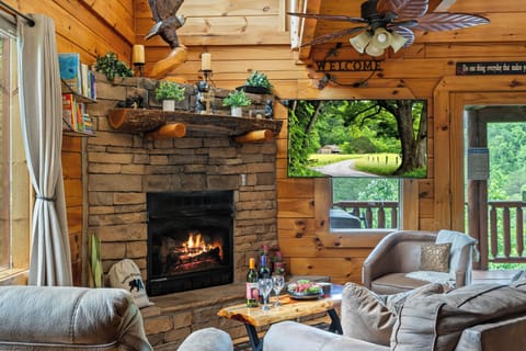 Main floor den with gas furnace fireplace and 55” tv; deck with hot tub