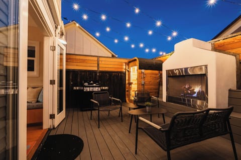 Relax and enjoy LoversPointRetreat private outdoor space complete with an outdoor lounge sitting around a huge gas fireplace. Twinkling overhead string lights set the mood.