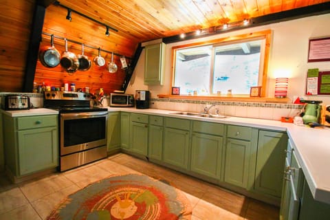 Kitchen has plenty of pots, pans, utensils, plates, & a view out to the river.