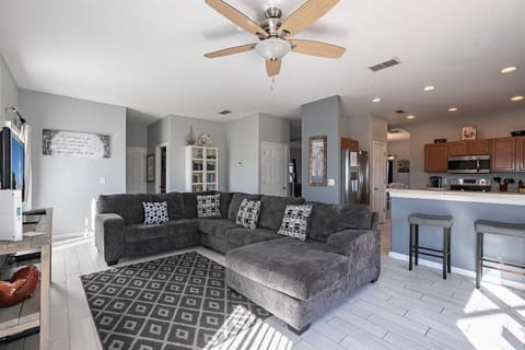 Relax in the open living room with comfortable seating and ceiling fan.