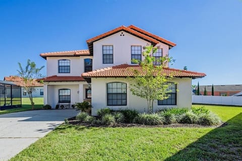 Stunning two-story home with a classic red tile roof and well-maintained landscaping.