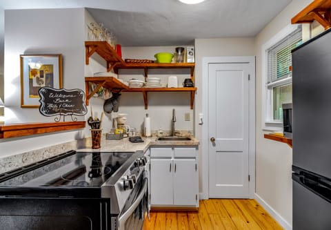 Fully stocked kitchen features a new stove/oven and refrigerator and deep sink