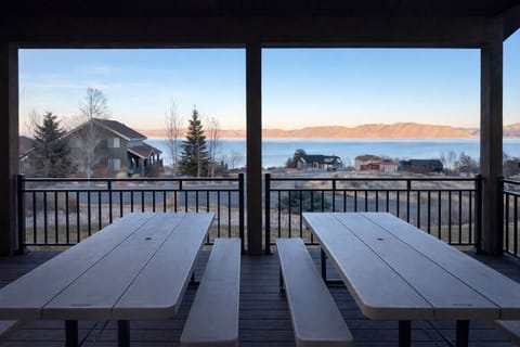 Spacious covered deck with seating for outdoor dining with a view.