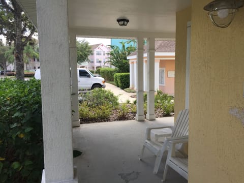 Wrap around patio with two adirondack chairs and two side tables.