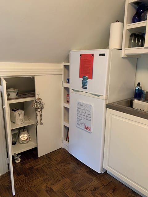 Kitchen has a closet with pull out rolling countertop with small appliances.