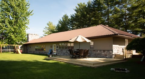 Spacious Back Yard with floating patio, grassy yard and swingset