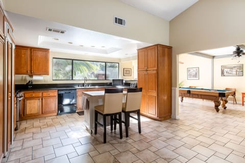 Open kitchen with views of the backyard pool and adjacent to the Billiard Room. 