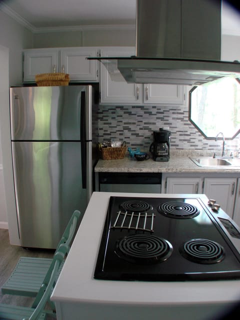 View of new stove, range hood, refrigerator and sink with lake view. 