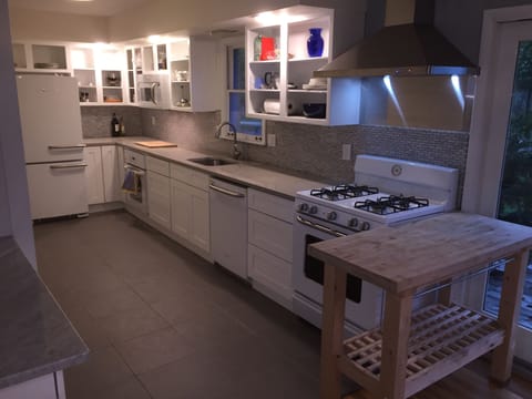 Kitchen full of pots, pans, serving dishes, utensils, and 30+ flatware settings