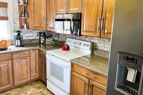 Kitchen with stainless appliances, stove, microwave & fridge.