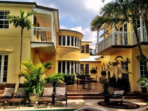 View of back patio w/couches, tables, lounges, swings, chairs in yard & on dock.