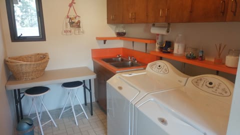 Utility room - Washer, dryer folding table, laundry detergent is provided.
