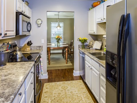 Another view of kitchen that is fully equipped with pots, pans, spices, dishes.