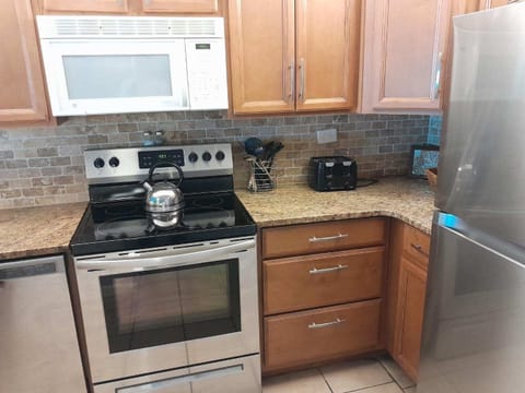 Stocked kitchen with granite countertops and open to livingroom and dining area