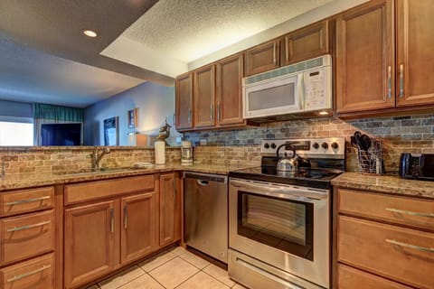 Fully stocked kitchen with appliances and cooking utensils.