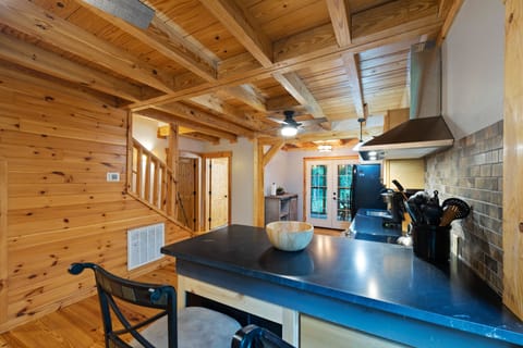 View of kitchen from bar top with 2 bar top stools