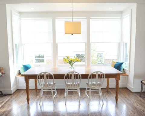 The dining area with a farm table and cozy window bench.