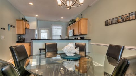Dining room with large glass top table and breakfast bar