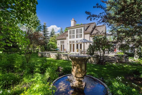 The lush backyard is a green oasis that transports you to the French countryside