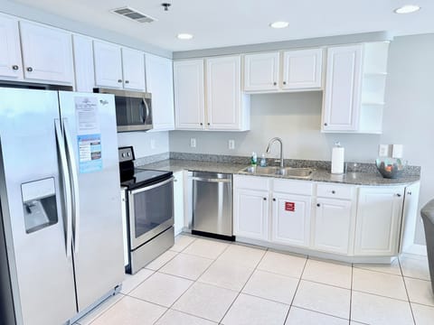 Kitchen w granite counters, all stainless appliances, white cabinetry