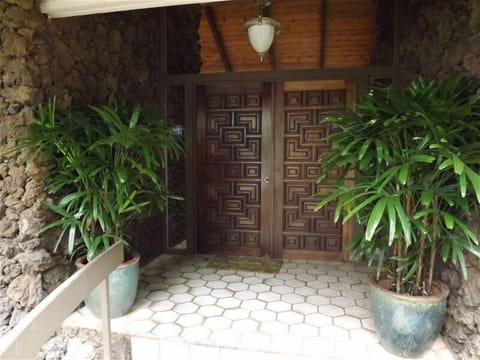 Hand carved double door entry with dramatic lava rock walls.