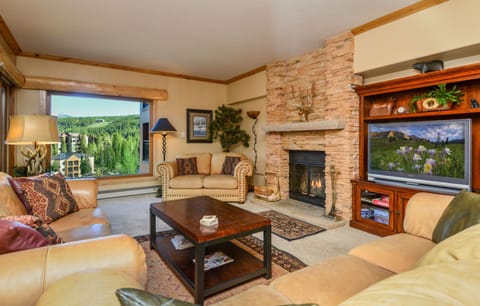 Beautifully appointed living room with wood burning fireplace and mountain views