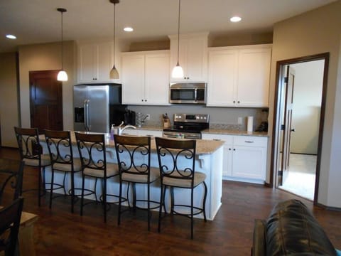 Bright airy kitchen with large island, granite countertops, and stainless steel appliances.