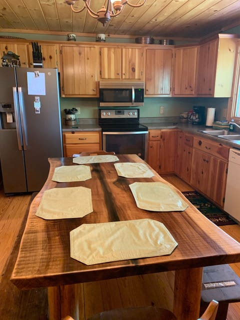 Kitchen, with stainless appliances, custom table and view of the mountains.