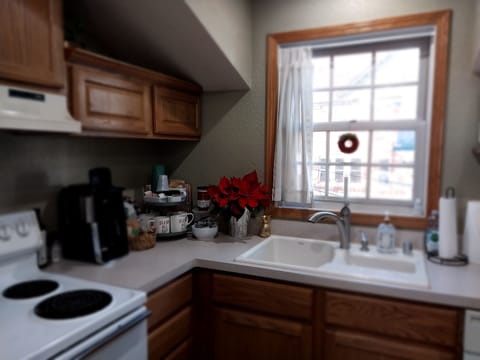 A beverage corner w/a drip coffee maker & tea kettle, condiments, & snacks