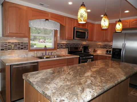 Open kitchen with island & custom tile design.
