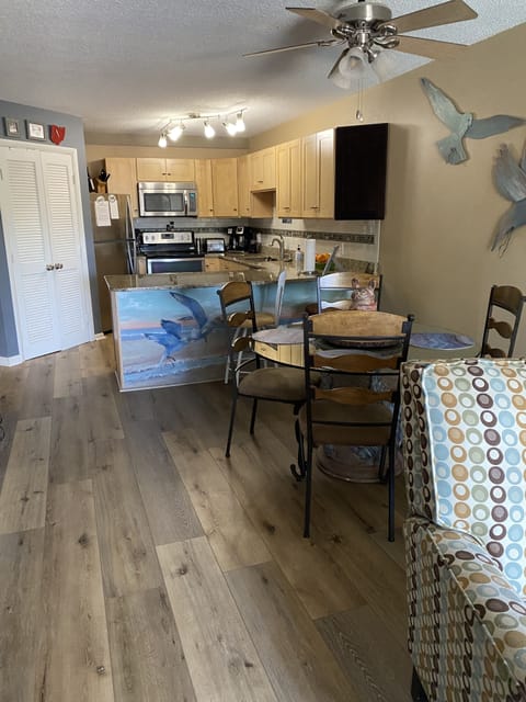 View of kitchen from living room area. New flooring throughout condo.