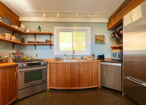 Rounded, tambour cabinets made by Doug Sigler and tableware by Fork Mountain Pottery in a decked out kitchen with almost anything you could possibly need: stand mixer, scale, blender, food processor, Instant Pot, and an extensive coffee setup!
