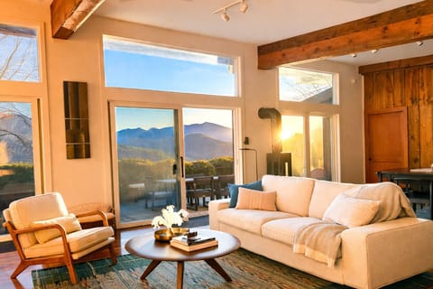 A comfortable sofa with cozy throws next to the gas log stove taking in the view