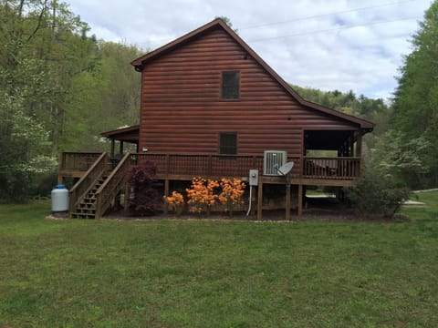 Side view of cabin with large grassy area 
