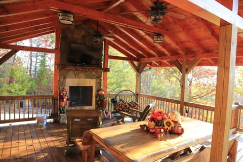 Covered deck with large tv, ceiling fans, rockers, and a view for family fun
