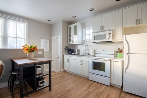 Well equipped kitchen with Carrera countertops and island for prepping/eating.