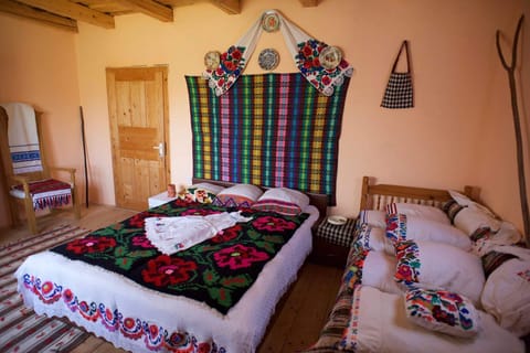 Our Triple Room shows hand made Maramures bed covers, wall hanging & pillowcases
