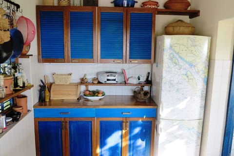 summer kitchen with high ceiling decorated with wooden beams; BBQ is next to
