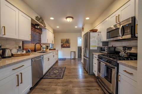 Brand new modern kitchen, marble counters, stainless appliances, deck adjacent. 