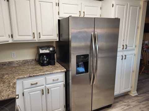 Coffee filters and coffee are on cupboard top shelf; electric kettle below