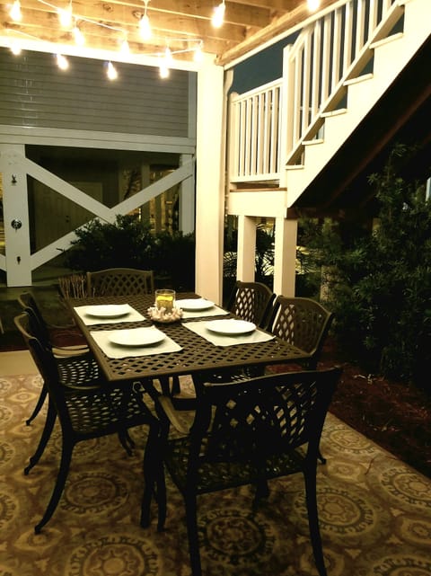 Covered outdoor dining with hanging lights for ambiance.  
