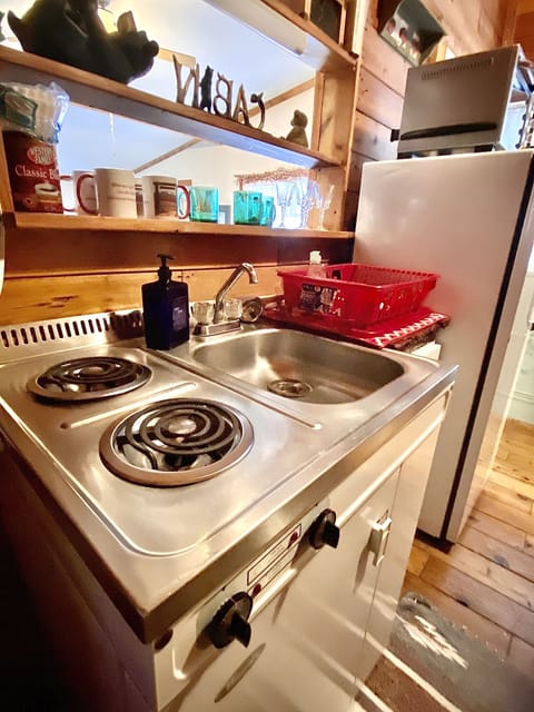The stove, sink, small fridge combination unit in the kitchen