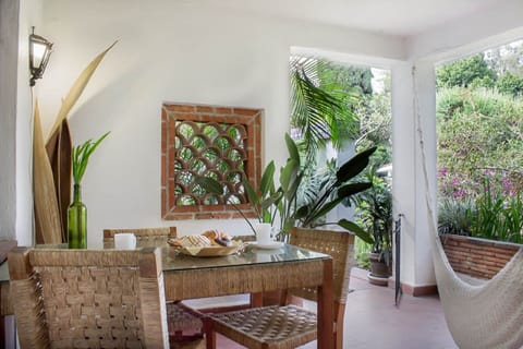 Terrace with hamock, table and chairs and with a view to the gardens.
