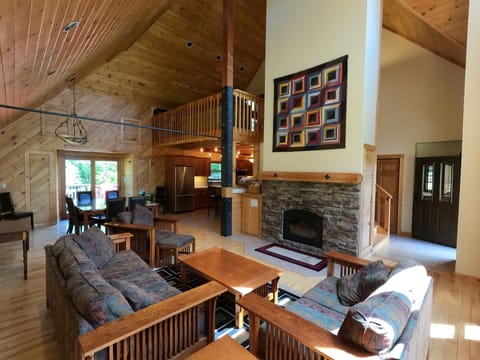 Great room with living and dining spaces and library loft above.