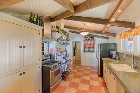 Large kitchen, concrete counter top, gas range, walk-in pantry in distance