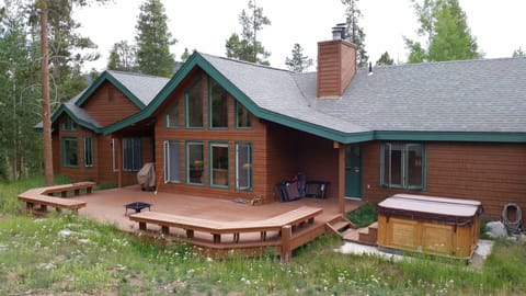 Rear view of house and deck and hot tub