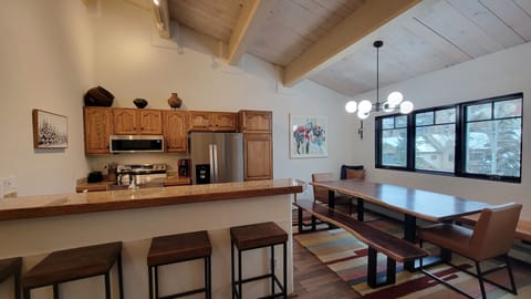 Banquette and bench seating flank the live edge table with leather end chairs.
